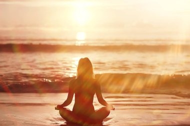 meditasyon ve yoga sahilde. Deniz kıyısında yoga yaparken genç kadın