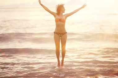 mutlu genç kadın eğleniyor ve kumsalda, özgürlük ve yaz tatil kavramı atlama