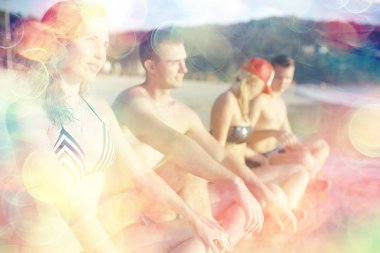 Sahilde, mutlu insanlar rahatlatıcı deniz kenarında güneşlenirken arkadaş grubu