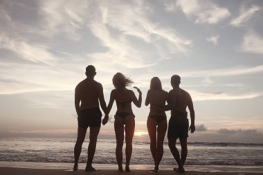 dört arkadaş Beach, yaz tatili ve mutluluk kavramı. Genç kadın denizde eğleniyor ve desteklemek