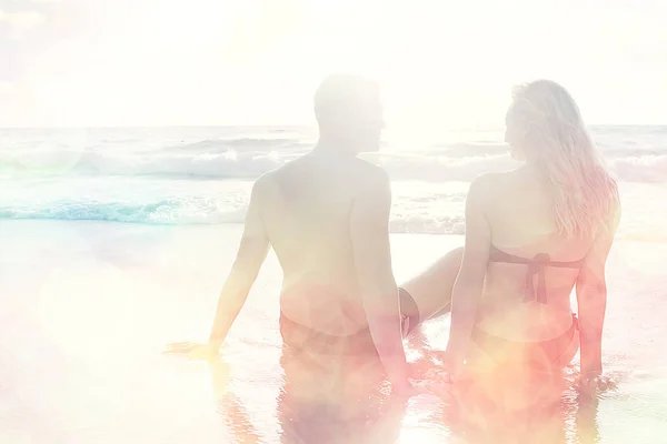 lovers at sandy beach, young guy and woman relaxing on the sea coast, the concept of summer holidays, vacation at sea