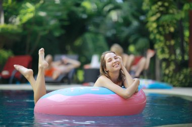 Kadın yüzme havuzunda şişme halkası üzerinde rahatlatıcı 