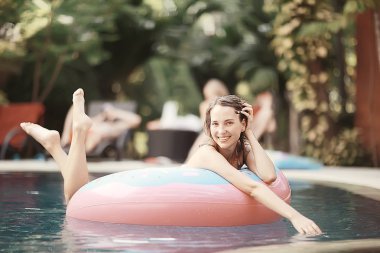 Kadın yüzme havuzunda şişme halkası üzerinde rahatlatıcı 