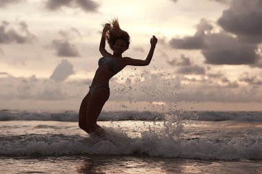 gün batımı, sağlıklı dinlenme, spor aktivite, yaz tatili denizde genç kadın silüeti