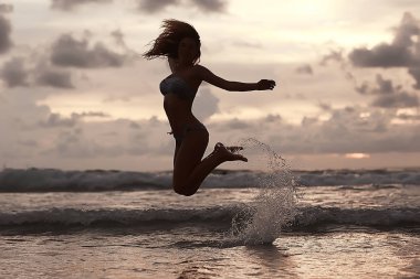 mutlu genç kadın eğleniyor ve kumsalda, özgürlük ve yaz tatil kavramı atlama