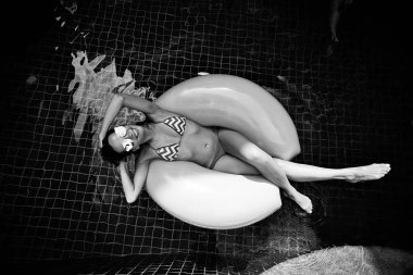 Kadın yüzme havuzunda şişme halkası üzerinde rahatlatıcı 