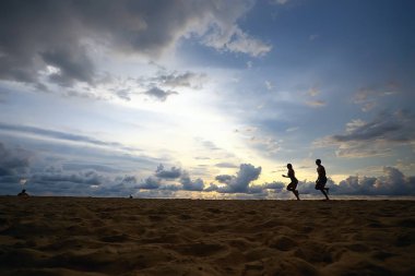 kumsal, yaz tatili boyunca çalışan iki sporcu siluetleri
