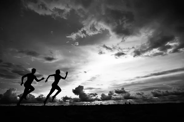 Силуэты Двух Спортсменов Бегающих Вдоль Пляжа Летние Каникулы — стоковое фото