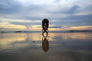 meditasyon ve yoga sahilde. Deniz kıyısında yoga yaparken genç kadın