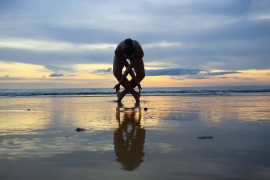 meditasyon ve yoga sahilde. Deniz kıyısında yoga yaparken genç kadın