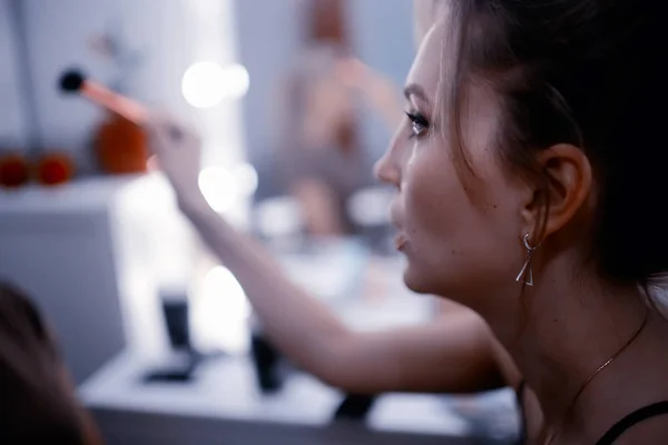 美容室でプロのメイクアップ 鏡の近くに座っている若いブロンドの女性 — ストック写真