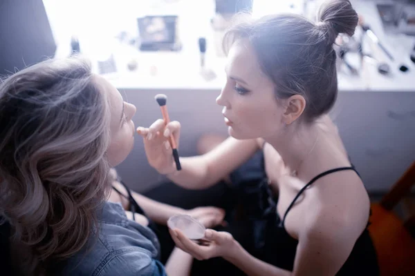 professional make-up in the beauty salon.  Master doing make-up for beautiful model in the salon