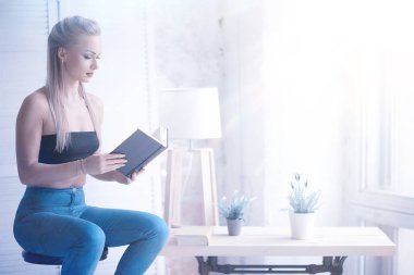 güzel genç sarışın kadın evde kitap okurken