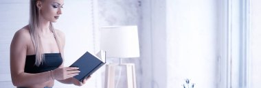 evde kitap okurken güzel sarışın genç kadın portresi