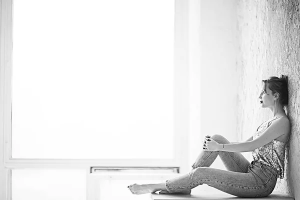 壁にもたれをポーズ スリム ジーンズを着て魅力的な若い女性 — ストック写真
