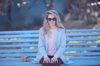 mutlu güzel genç kadın parkta bankta oturan 