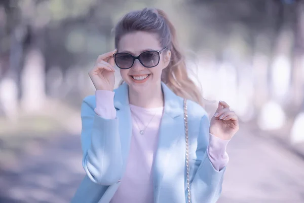 公園でスタイリッシュな青いコートを着ている金髪美人 — ストック写真