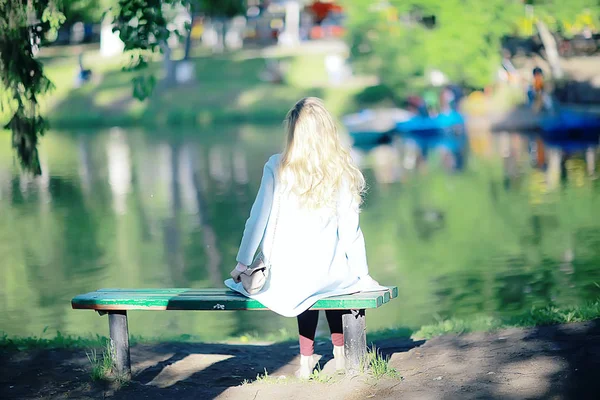 在公园长凳上休息愉快的美丽的年轻妇女 — 图库照片