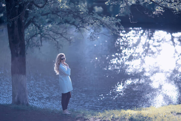 Beautiful woman posing near lake in autumn park