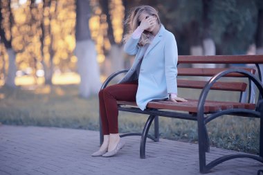 mutlu güzel genç kadın parkta bankta oturan 