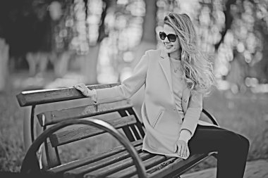 mutlu güzel genç kadın parkta bankta oturan 