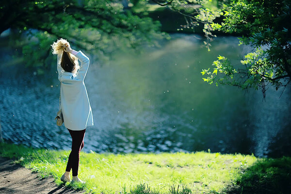 Beautiful blonde woman wearing stylish blue coat in park