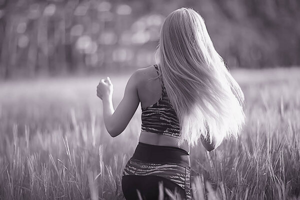 Young beautiful woman with long hair posing at oat field, summer vacation