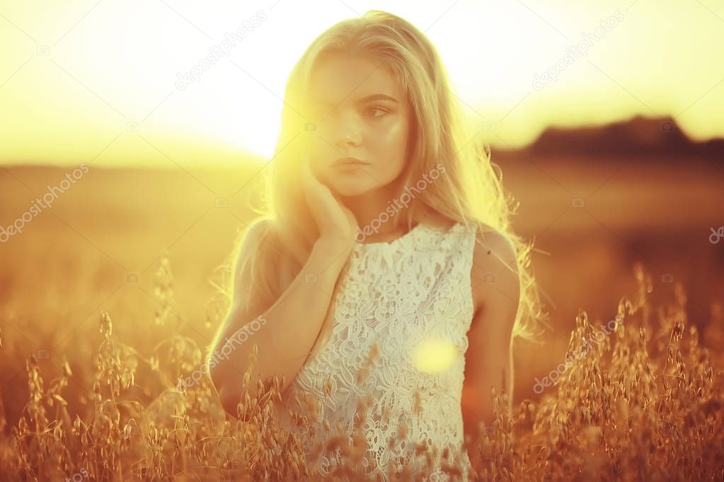 beautiful young woman in rural field at sunset, summer vacation