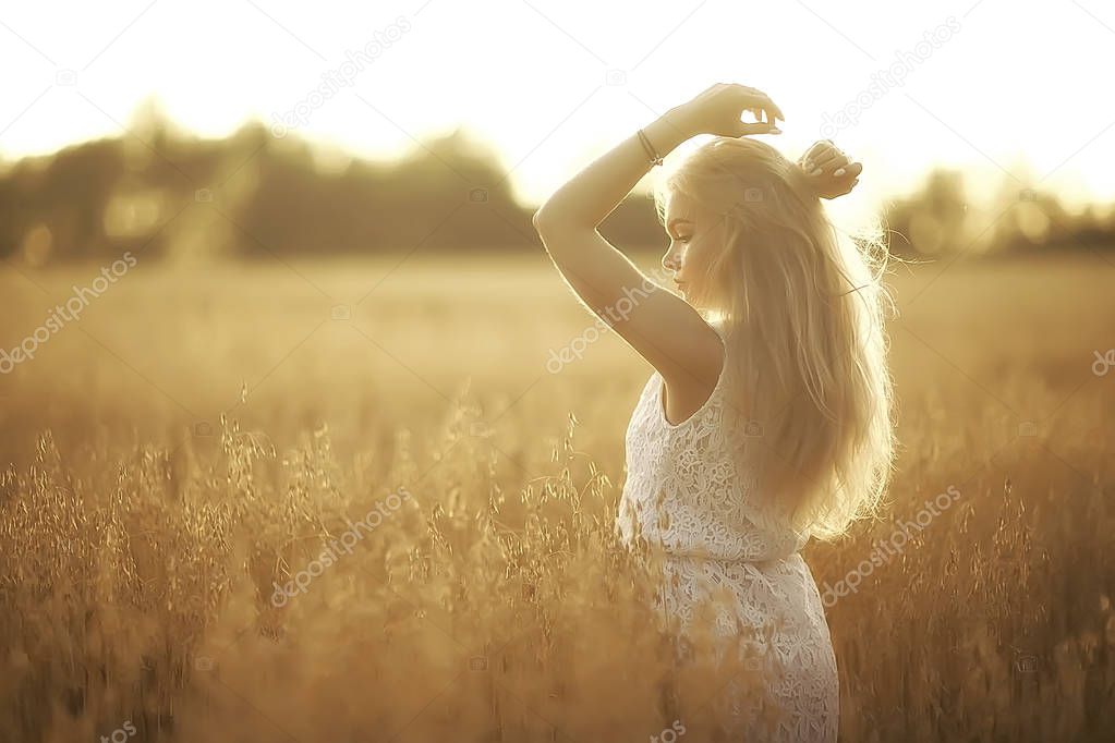 young beautiful woman with long hair posing at oat field, summer vacation