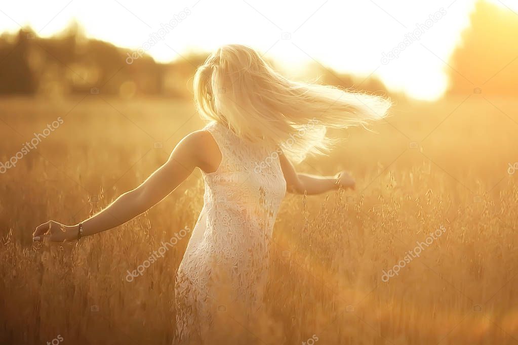 young beautiful woman with long hair posing at oat field, summer vacation
