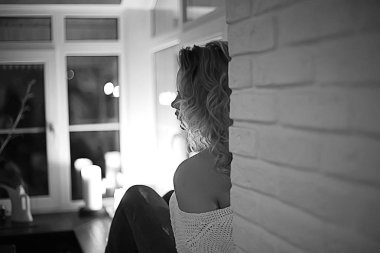 Beyaz örgü kazak evde poz içinde sarışın genç kadın