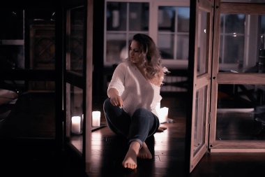 Beyaz örgü kazak evde poz içinde sarışın genç kadın