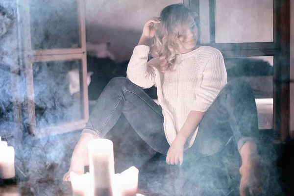 Молодая Блондинка Белом Трикотажном Свитере Позирует Темной Комнате Дымом — стоковое фото