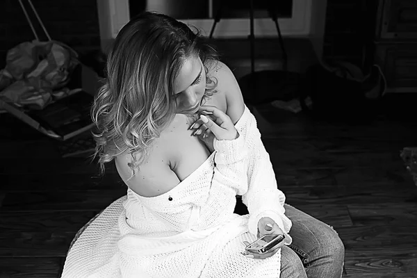 白いニットのセーター ポーズ自宅に若いブロンドの女性 — ストック写真