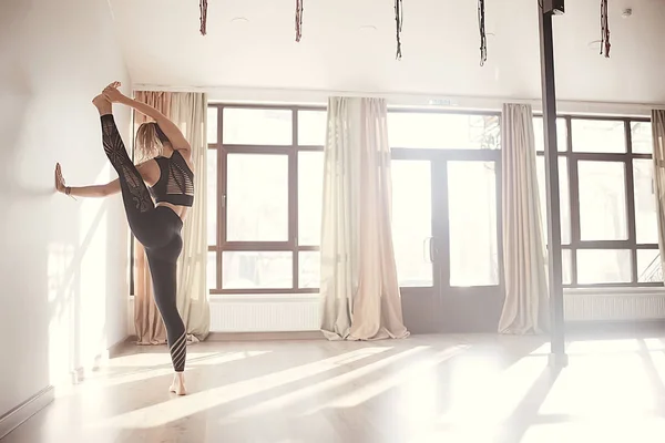 young flexible woman doing gymnastics in gym, stretching, healthy body, sports training