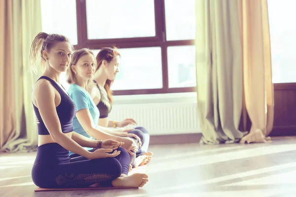 young and flexible women doing yoga in gym