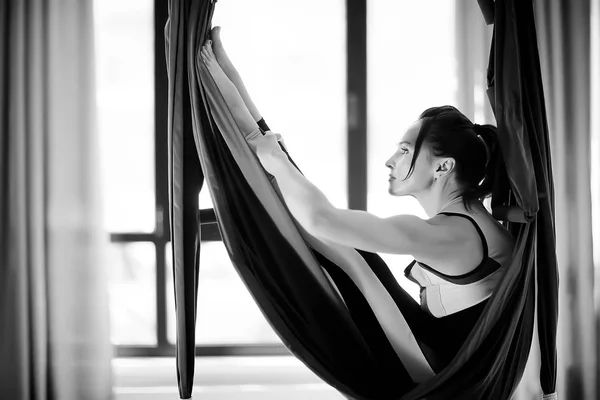 yoga in hammock. Sport and active lifestyle. Young female coach doing yoga in a hammock