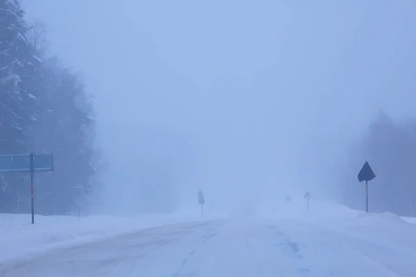 snow and fog on winter road, winter lonely landscape