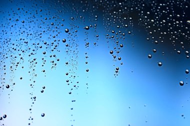 mavi ıslak arka planı, pencere camına yağmur damlaları, sonbahar hava kavramı