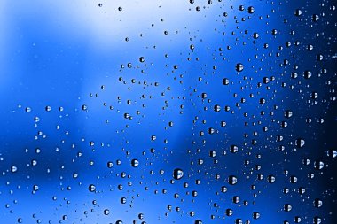 mavi ıslak arka planı, pencere camına yağmur damlaları, sonbahar hava kavramı