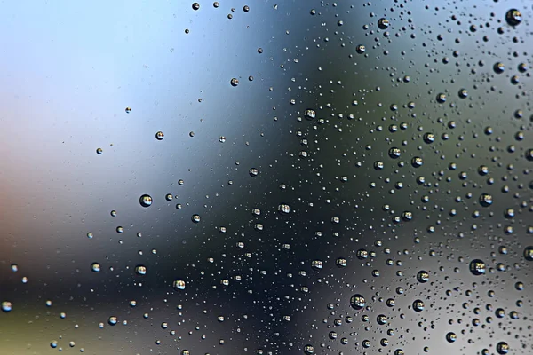 gray wet background, raindrops on window glass, concept of autumn weather