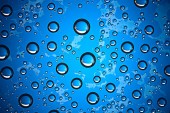 modré pozadí vlhké, kapky deště na okenní sklo, pojem podzimní počasí