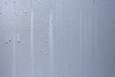 gri arka planı, pencere camına yağmur damlaları, sonbahar hava kavramı ıslak
