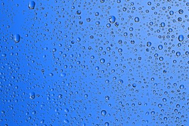 mavi ıslak arka planı, pencere camına yağmur damlaları, sonbahar hava kavramı