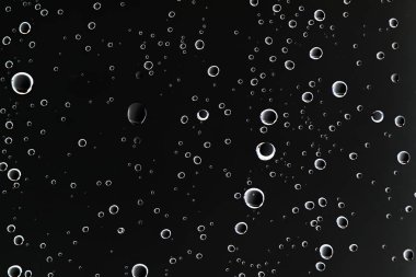 siyah ıslak arka planı, pencere camına yağmur damlaları, sonbahar hava kavramı