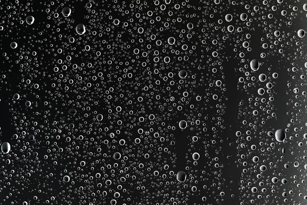 black wet background, raindrops on window glass, concept of autumn weather