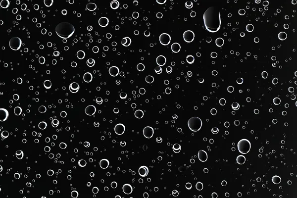 black wet background, raindrops on window glass, concept of autumn weather