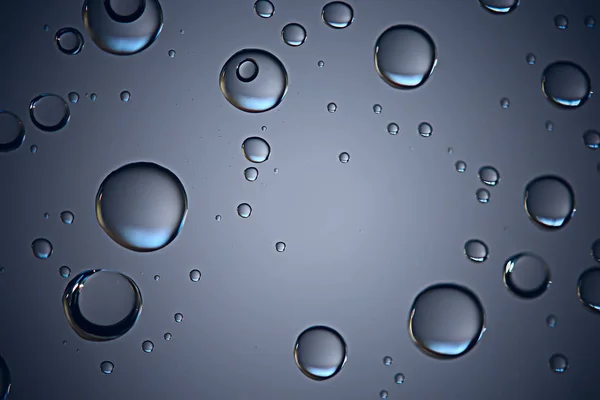 gray wet background, raindrops on window glass, concept of autumn weather