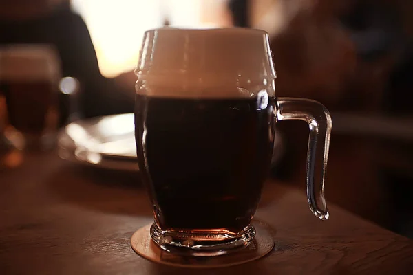 テーブルの上のビールのジョッキがぼやけて暗いレストランの背景 — ストック写真