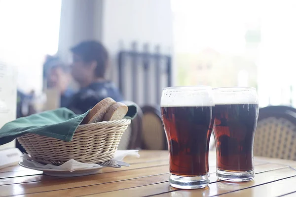 チェコ共和国でのレストランでお召し上がりいただけますテーブル上の泡とビールのパイントのパブの内部に黒ビールのマグカップ — ストック写真
